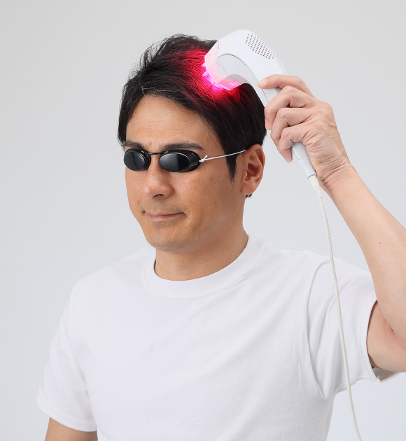 おっさんが赤いLEDを頭にキメている画像